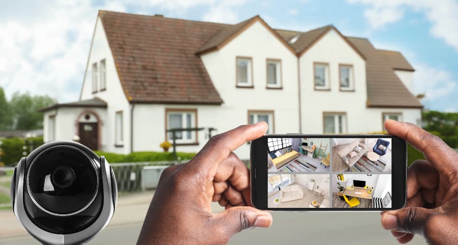 Man holding mobile device and looking at streams from video cameras